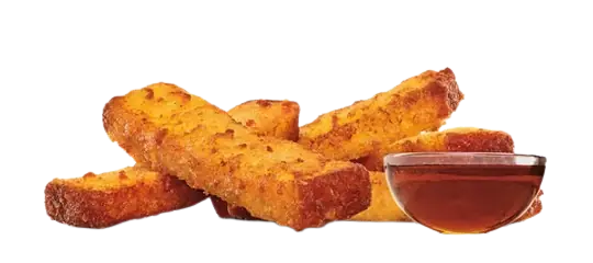 A pile of golden-brown French toast sticks sitting next to a small clear bowl of maple syrup.