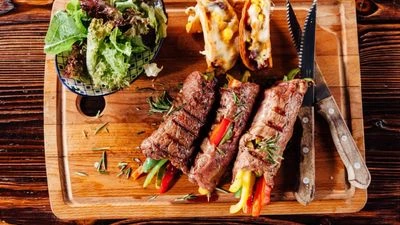 Gourmet grilled beef rolls stuffed with vegetables on a wooden platter