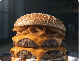 A double-patty cheeseburger topped with crispy onion rings on a sesame seed bun.