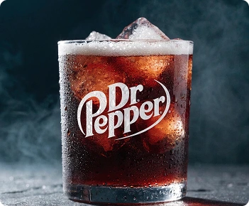Dr Pepper logo on a chilled glass with ice cubes and condensation.
