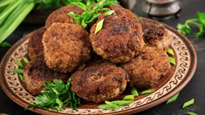 Platter of fried Shami kababs garnished with fresh coriander and chillies.